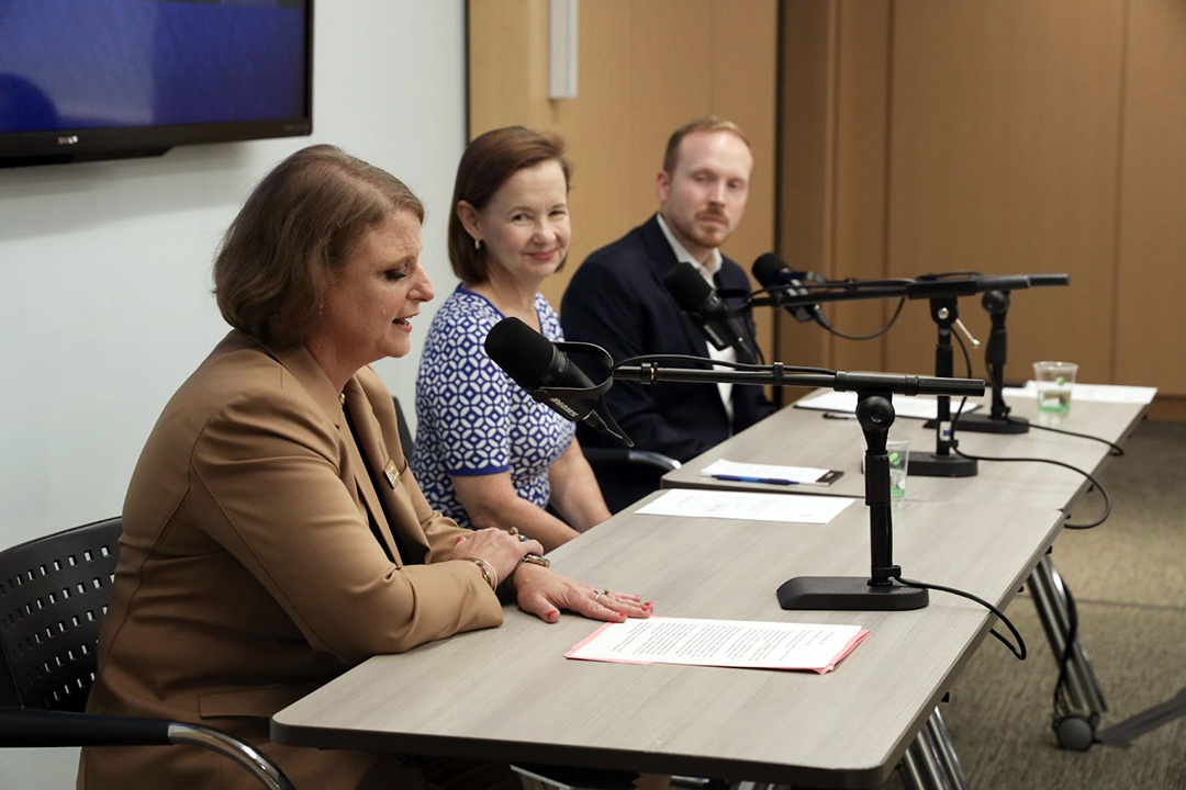 CPS Dean Riddle, Sharon McBride and Anthony Shop sitting at a table in front of microphones