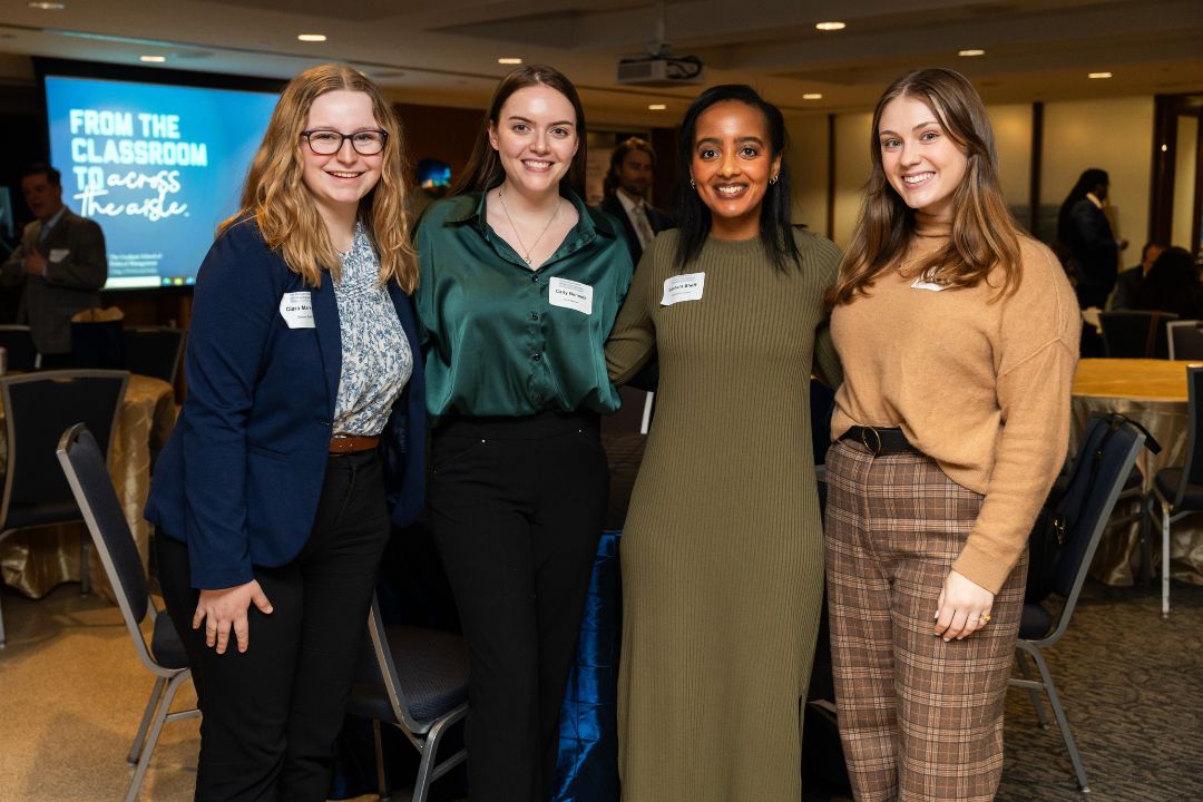 Four students smiling and posing