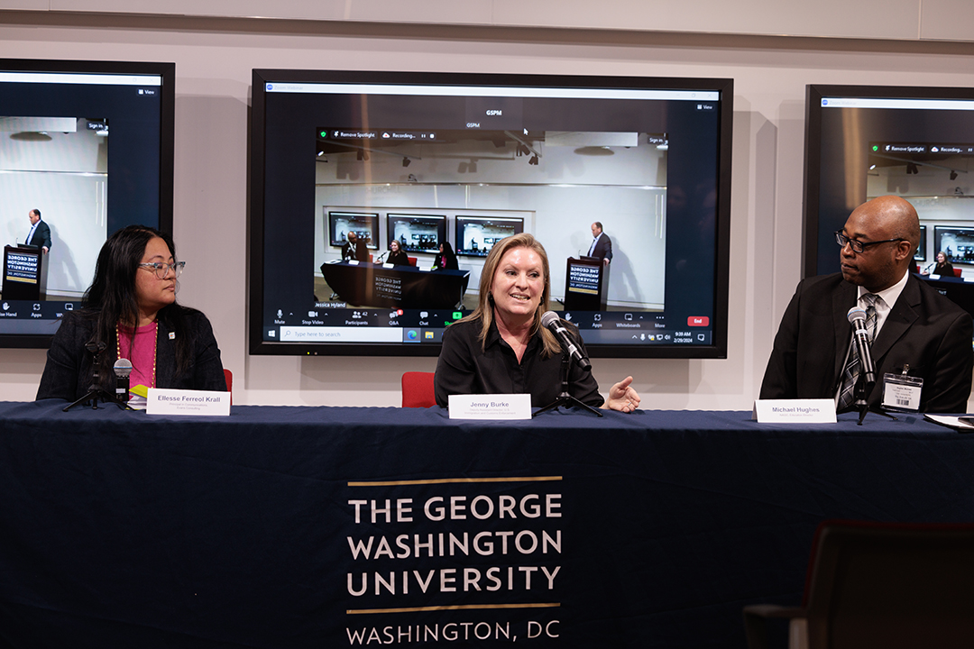 Panel of two women and a man sitting at a table with GW logo on tablecloth