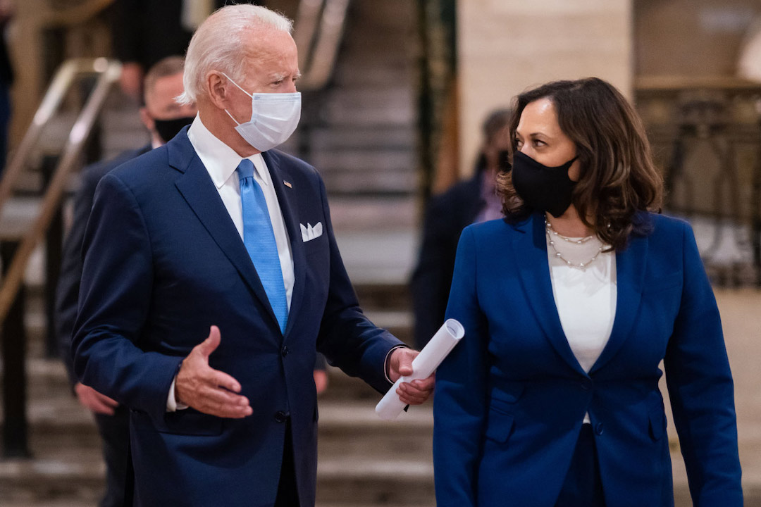 Joe Biden and Kamala Harris, both wearing blue suits and face masks