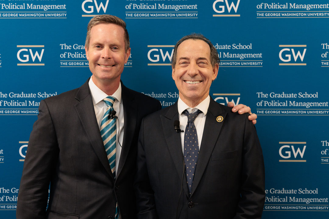 Rodney Davis and Jamie Raskin smiling in front of step-and-repeat