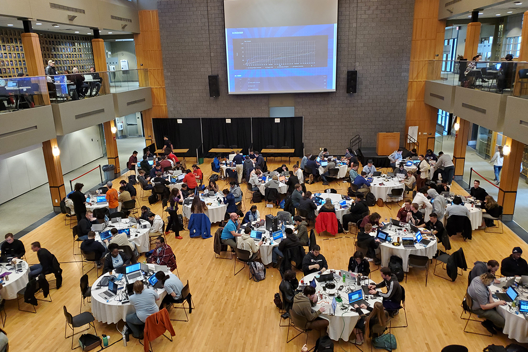 Wide view of the competition with many round tables of competitor teams