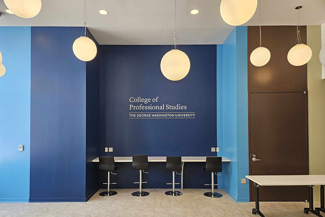 "Bar style" study area. The bar table rests on a dark blue wall branded with the CPS logo.
