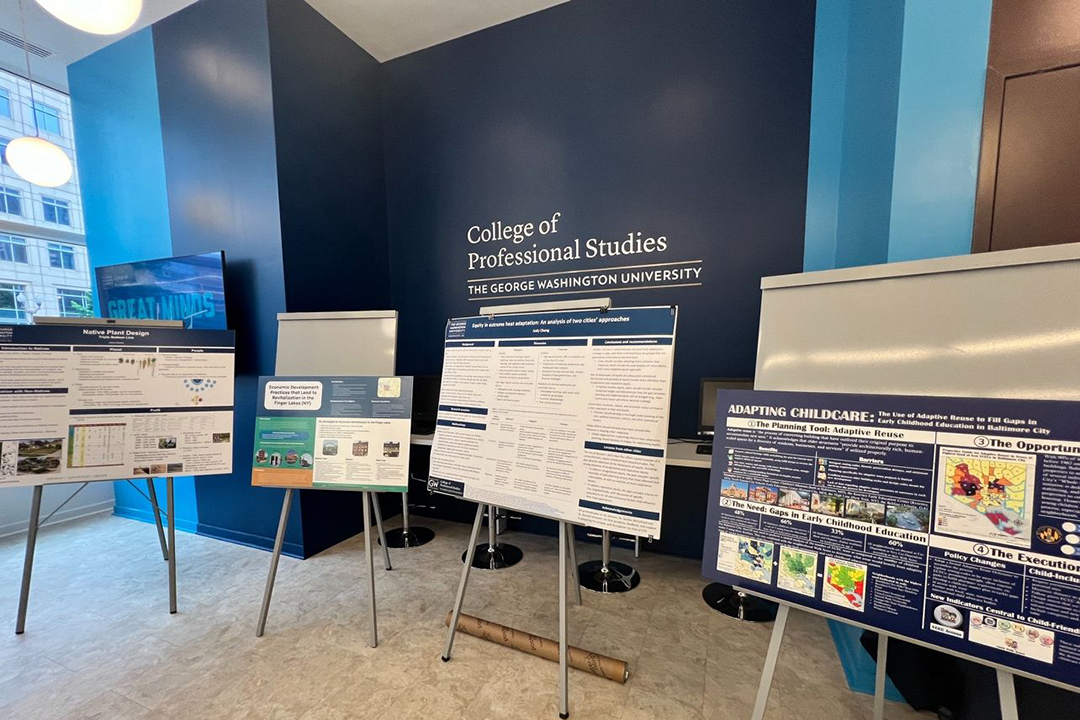 Four posters on display in GW CPS lobby with bright blue and darker blue walls