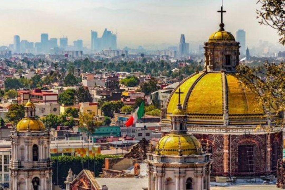 Basilica de Guadalupe exterior with the skyline of Mexico City in the background