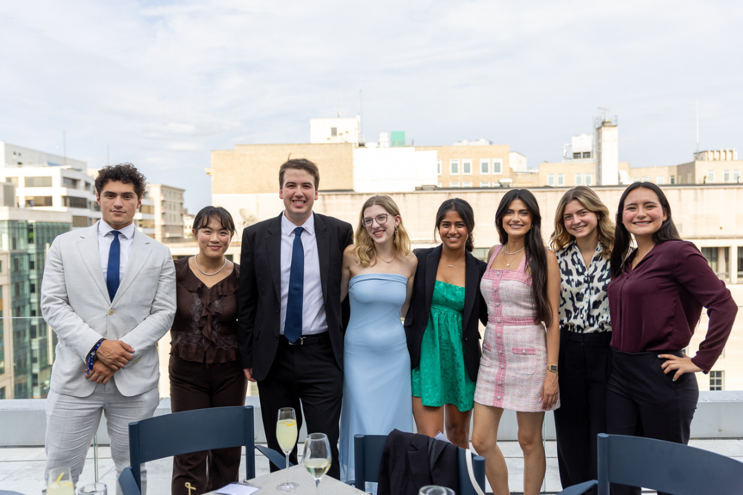 Students smile and pose together with DC skyline behind them.