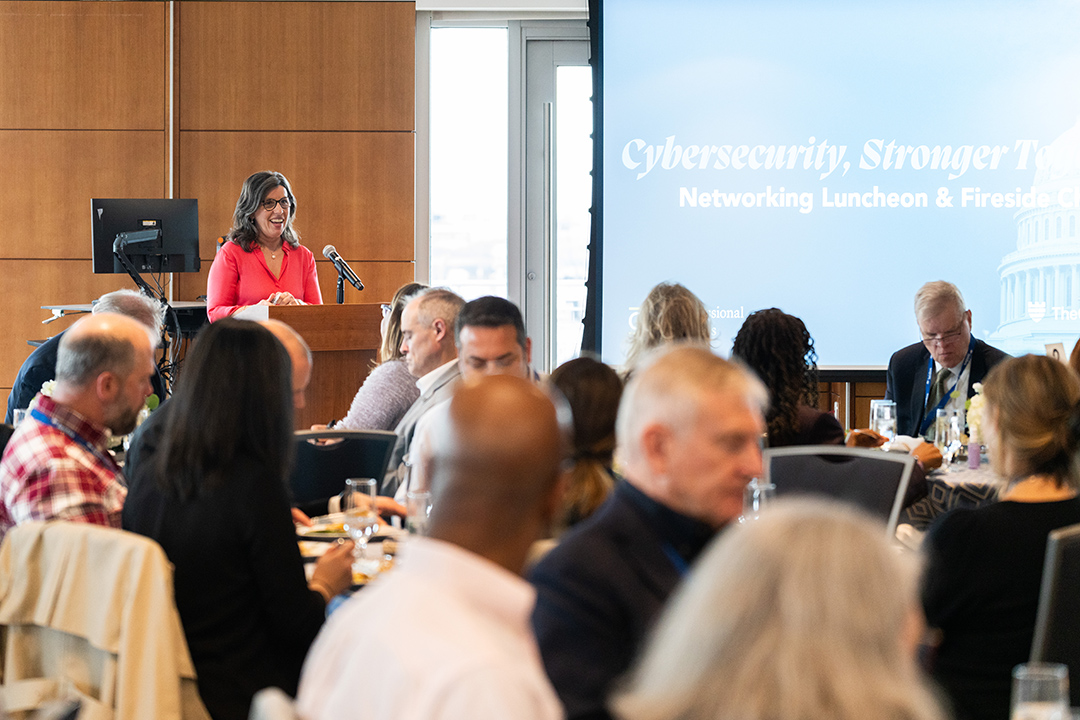 woman at podium at crowded lunch event