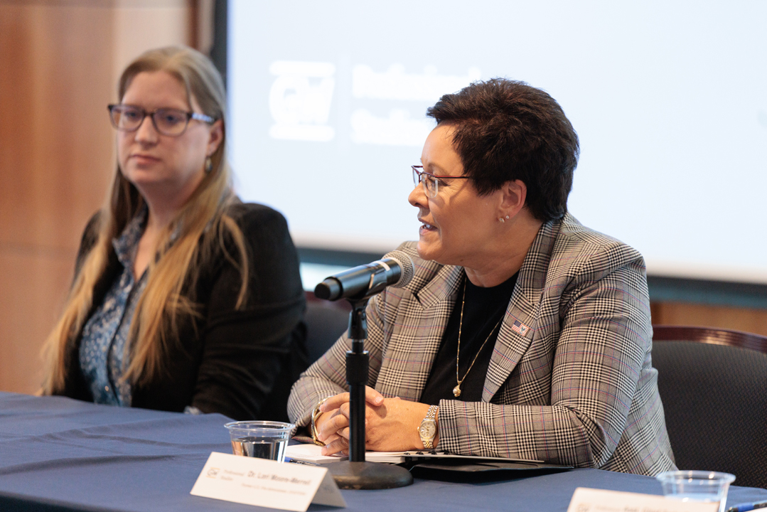 Dr. Christine de Souza and Dr. Lori Moore-Merrell sitting at podium