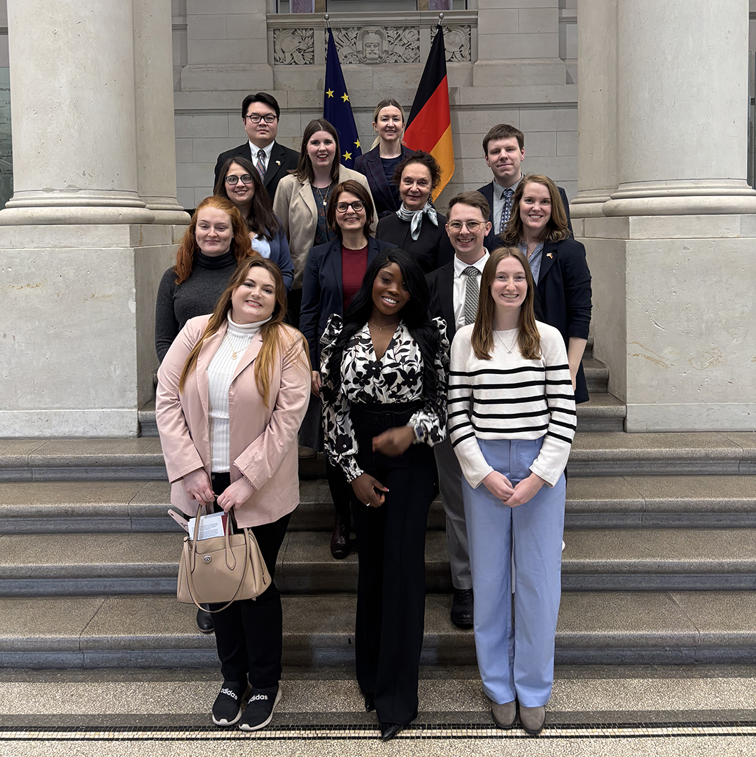 student group in Berlin with flag in front of columns