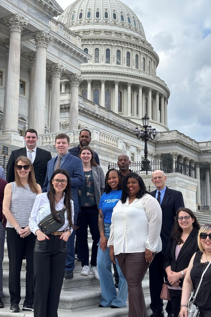 Students pose in front of the Capitol Building with John Lawrence, former Chief of Staff to Speaker Nancy Pelosi.