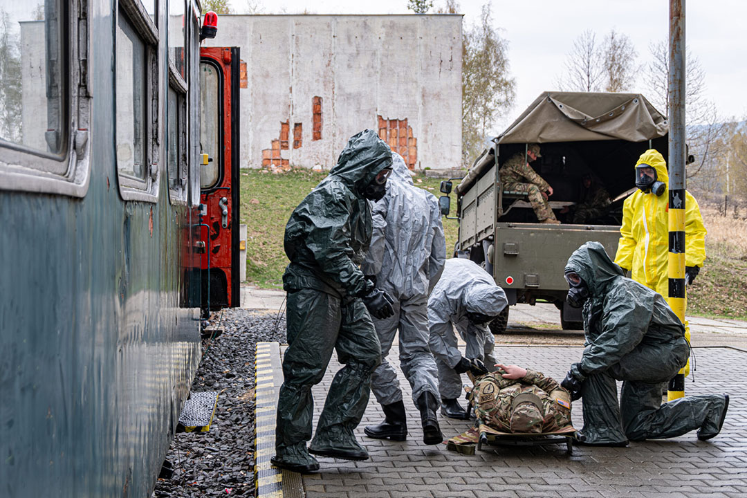 emergency management simulation with 5 people working with a dummy wearing hazmat equipment