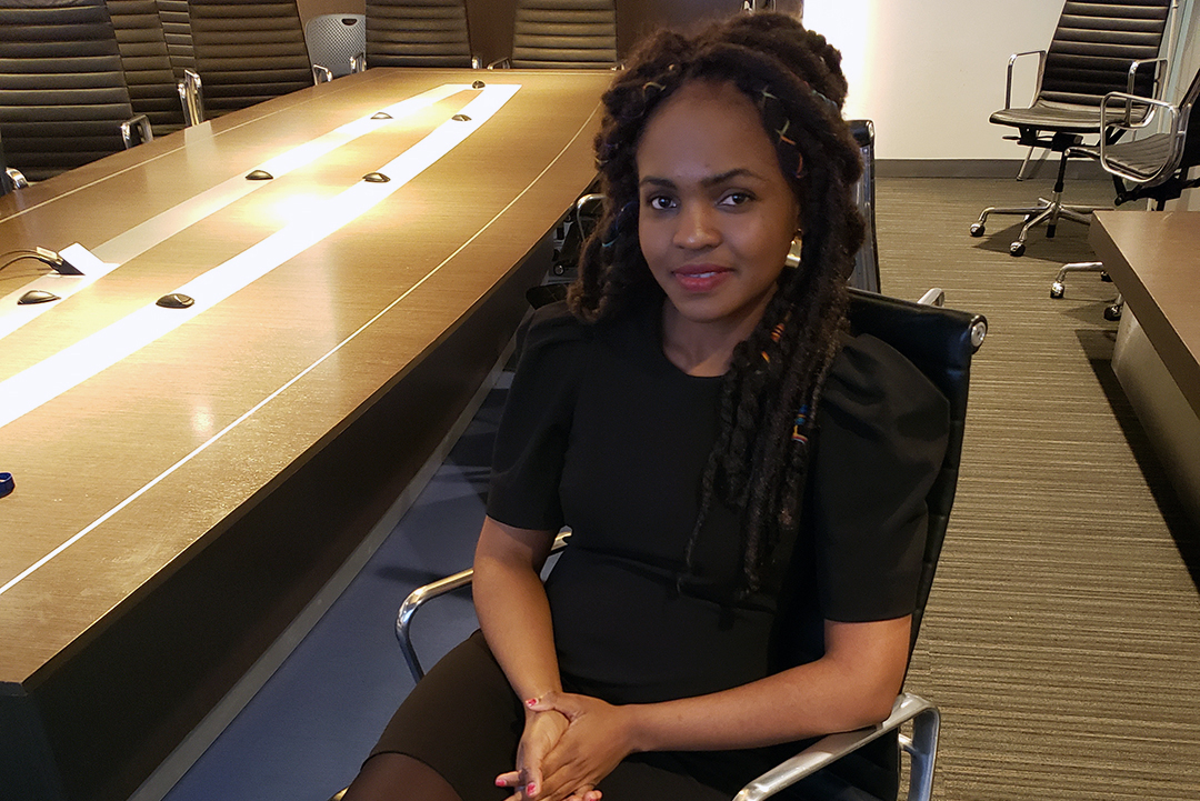 Alvine Ntandu, alumna in black dress in conference room