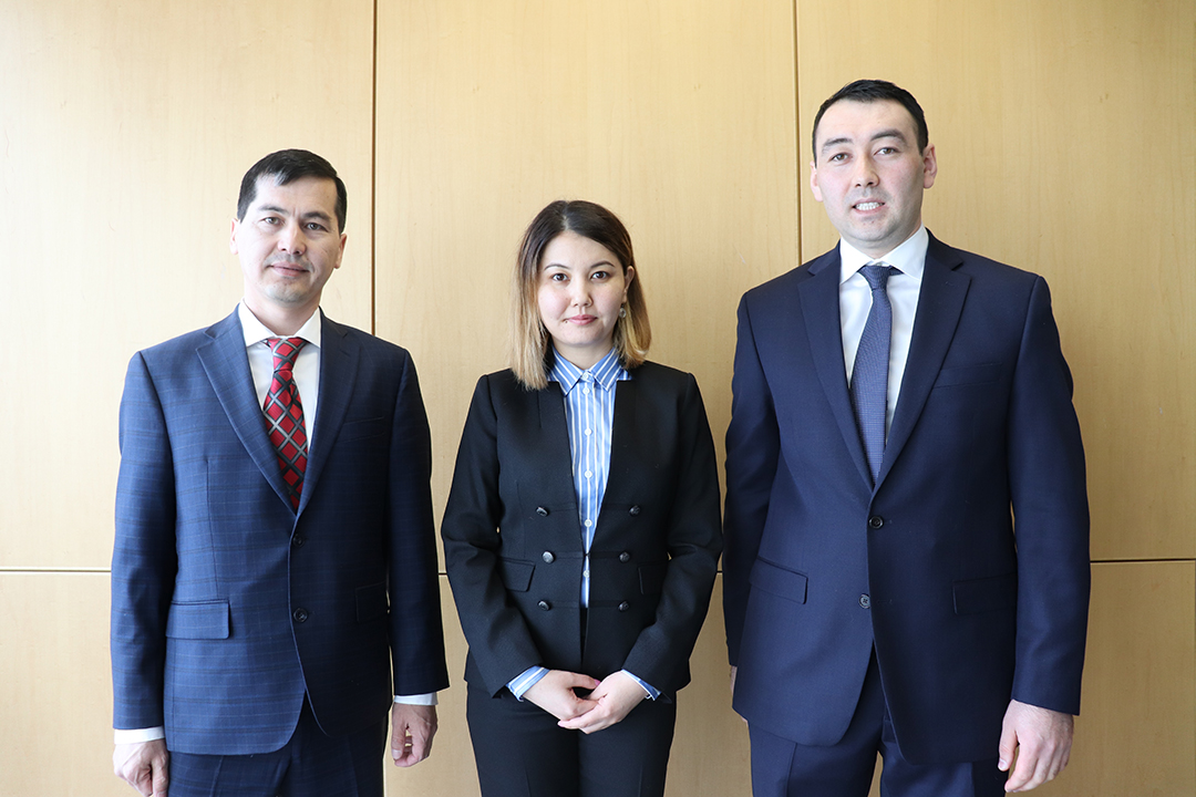 2 men, one woman in the center, all in suits, semifinalists in competition