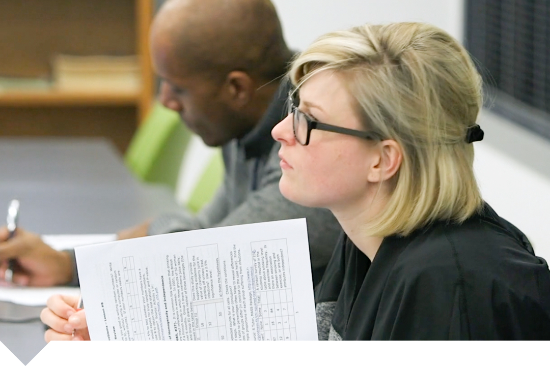 Student looking to left with papers in her hand