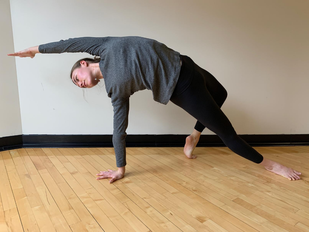 Woman in athletic clothing doing a side stretch yoga pose 