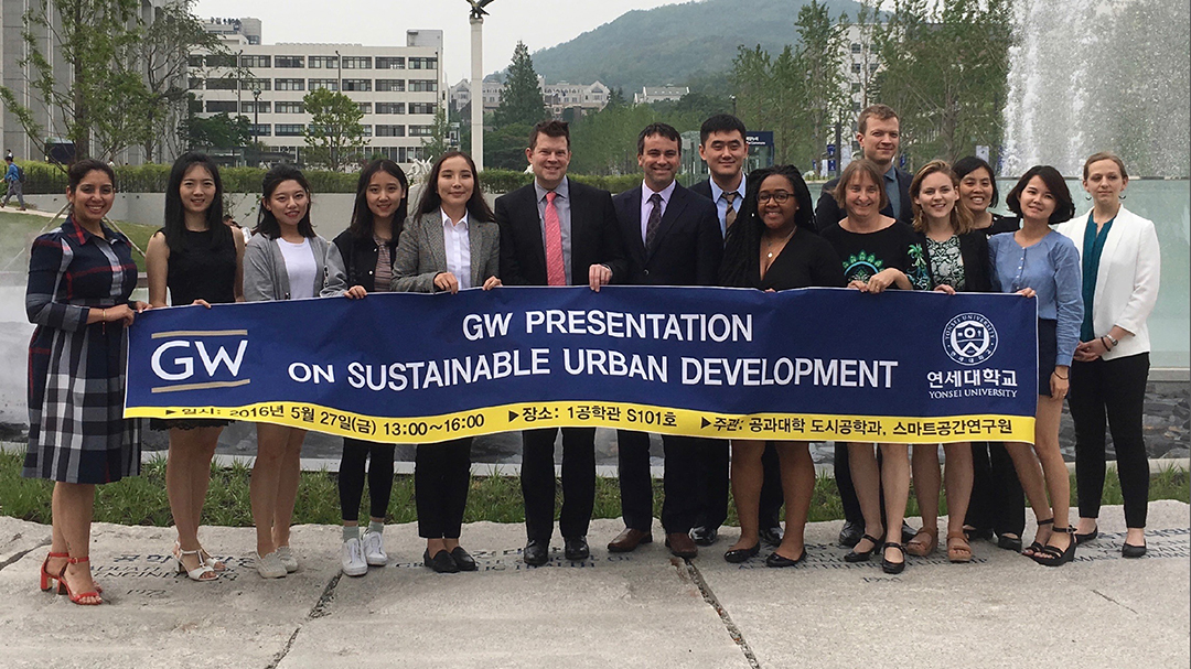 SUP student group with Program Director John Carruthers hold banner with words Sustainable Urban Planning Program, GW 