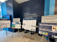 Four posters on display in GW CPS lobby with bright blue and darker blue walls