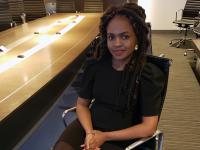 Alvine Ntandu, alumna in black dress in conference room