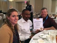 CPS marketing team holding award certificate at lunch in ballroom