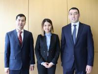 2 men, one woman in the center, all in suits, semifinalists in competition