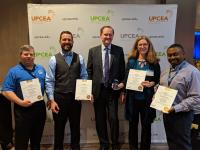 4 CPS Marketing team members and UPCEA president pose with award certificates.