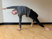 Woman in athletic clothing doing a side stretch yoga pose 