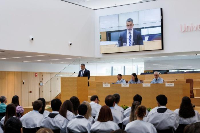 University of Navarra graduates watch Martin Velazquez give a speech from the podium in front of them