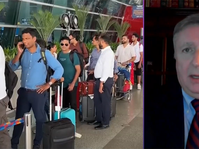 Scott White media interview and large line of people at airport with suitcases