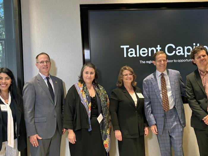 Dr. Ximena Gates Hartsock, Dr. Paul Kihn, Dr. Ina Gjikondi, Dr. Andrew Flagel, and Kyle Detrich pose in front of Talent Capital sign.