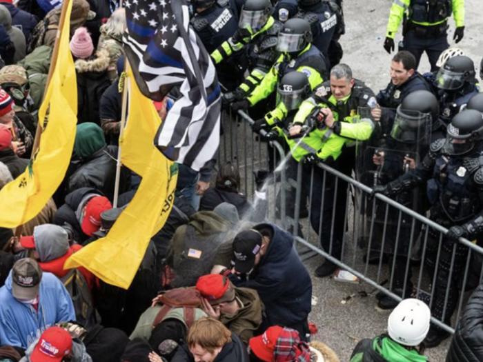 violent mob of people with barrier and police