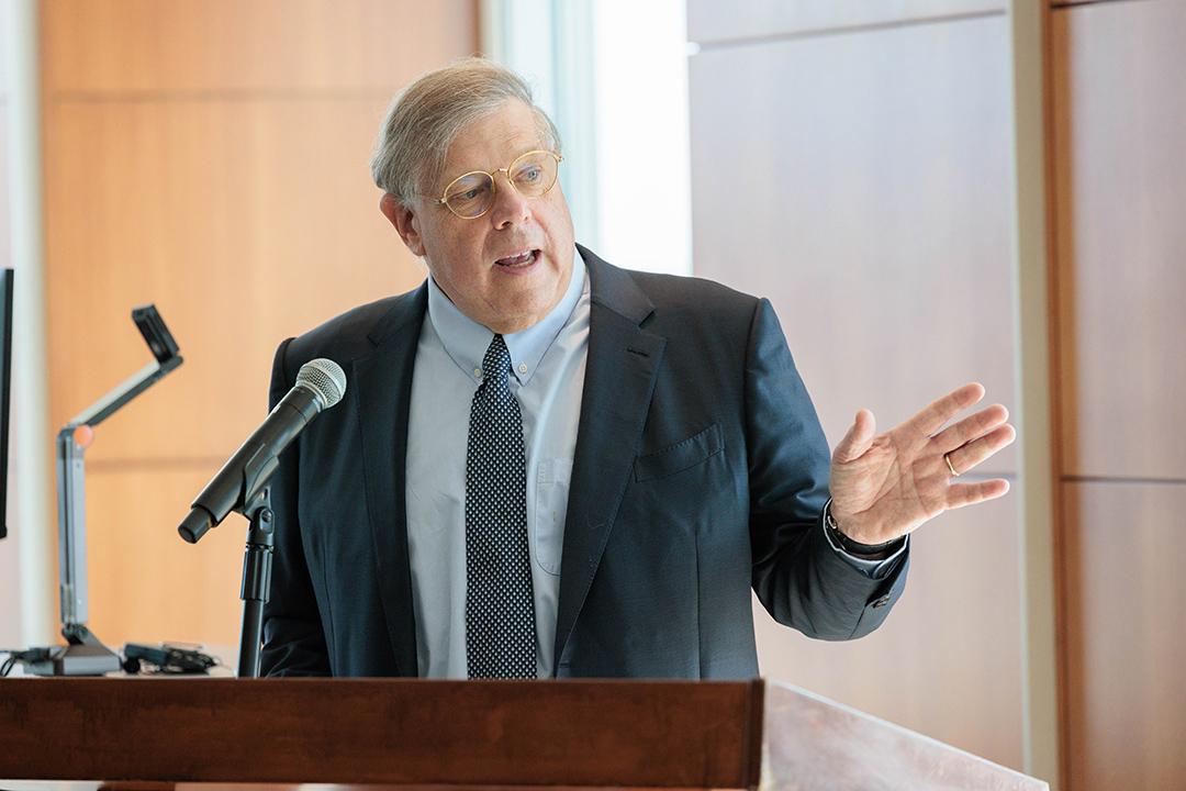 Mark Penn standing and speaking at a podium