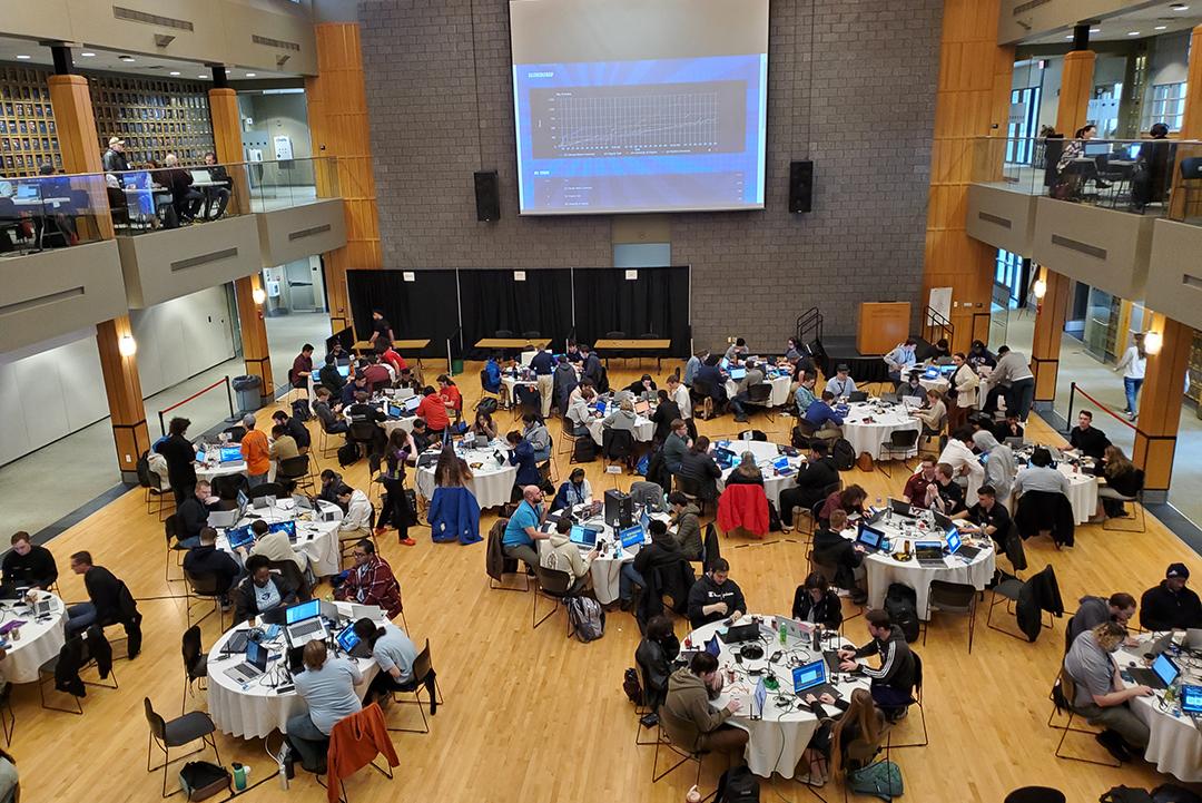 Wide view of the competition with many round tables of competitor teams