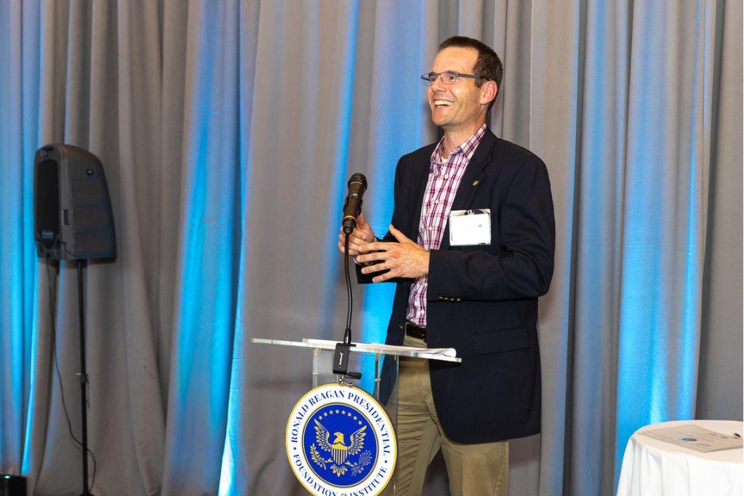 Dr. Tobias Greiff speaking at podium