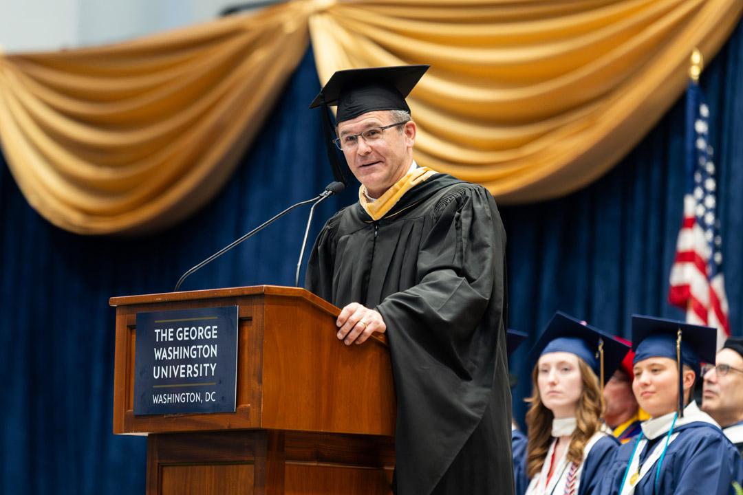 Colby Jenkins speaking onstage at a podium