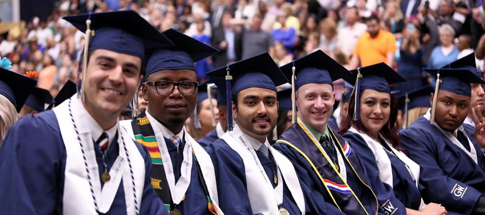 graduation in Smith Center with a group of male and female graduates smiling in graduation hats and gowns