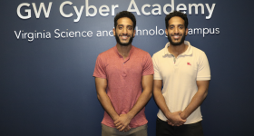 Twin brothers, students in front of GW Cyber Academy sign