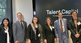 Dr. Ximena Gates Hartsock, Dr. Paul Kihn, Dr. Ina Gjikondi, Dr. Andrew Flagel, and Kyle Detrich pose in front of Talent Capital sign.